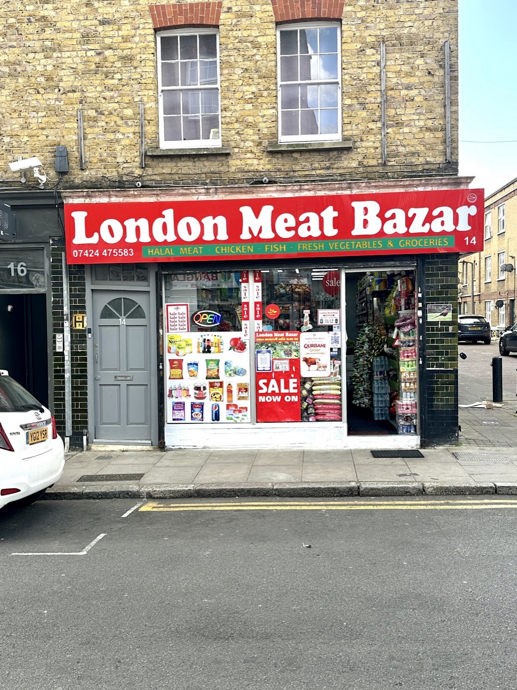 The London Meat Bazar shopfront on Fordham Street, Whitechapel, with its red halal meat, chicken, fish and groceries signage
